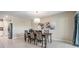 Cozy dining area illuminated by an elegant chandelier, featuring a wooden table and access to outdoor patio at 8749 Parsons Hill Blvd, Wesley Chapel, FL 33545