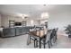 Bright dining area with a chandelier, wooden table, and seating for six adjacent to the living room at 8749 Parsons Hill Blvd, Wesley Chapel, FL 33545