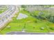 Aerial view of fenced dog park with agility equipment and pond, perfect for pet owners at 8749 Parsons Hill Blvd, Wesley Chapel, FL 33545