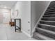Inviting hallway with stairway and tiled floor, featuring a table with decor and coat rack at 8749 Parsons Hill Blvd, Wesley Chapel, FL 33545