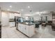 Open concept kitchen flows seamlessly into the living area, offering an island with seating and stainless steel appliances at 8749 Parsons Hill Blvd, Wesley Chapel, FL 33545