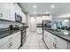 Well-lit kitchen featuring granite countertops, stainless steel appliances, white cabinets, and a convenient center island at 8749 Parsons Hill Blvd, Wesley Chapel, FL 33545