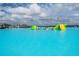 Lagoon view of inflatables and other water activities under a partly cloudy sky at 8749 Parsons Hill Blvd, Wesley Chapel, FL 33545