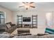 Comfortable living room featuring a ceiling fan, TV with shelves, and a gray sofa with ottoman at 8749 Parsons Hill Blvd, Wesley Chapel, FL 33545