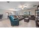 Inviting living room adjacent to dining area with a large gray sectional sofa, teal recliner and bright recessed lighting at 8749 Parsons Hill Blvd, Wesley Chapel, FL 33545