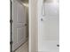 Modern tiled shower with white tile and chrome fixtures next to open door at 8749 Parsons Hill Blvd, Wesley Chapel, FL 33545