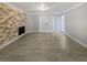 Spacious living room with a brick fireplace, neutral walls, tiled floors and bright white trim at 9481 Highland Oak Dr # 703, Tampa, FL 33647