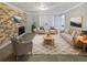Inviting living room featuring a brick fireplace, neutral decor, stylish furnishings, and a soft patterned rug at 9481 Highland Oak Dr # 703, Tampa, FL 33647