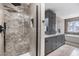 Modern bathroom with a walk-in shower, vanity, and a soaking tub next to a window at 9481 Highland Oak Drive # 602, Tampa, FL 33647