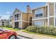 Two-story condo with tan exterior and white trim, small balcony, and well-maintained landscaping at 9481 Highland Oak Drive # 602, Tampa, FL 33647