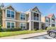 Tan two-story condo featuring white trim, a screened balcony, and green landscaping at 9481 Highland Oak Drive # 602, Tampa, FL 33647