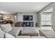 Comfortable living room featuring a gray sectional sofa, TV and sleek furnishings at 9481 Highland Oak Drive # 602, Tampa, FL 33647