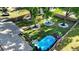 Aerial view of a fenced backyard with a pool, a circle of Adirondack chairs, and mature trees at 9616 Oak Ridge Ave, Riverview, FL 33578