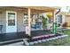 Inviting front porch with a swing and decorative flower accents at 9616 Oak Ridge Ave, Riverview, FL 33578