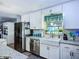 Updated kitchen with stainless steel appliances, farmhouse sink, and stylish backsplash at 9616 Oak Ridge Ave, Riverview, FL 33578