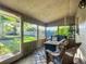 Enclosed porch featuring wicker furniture, creating an inviting space for relaxation and entertainment at 9616 Oak Ridge Ave, Riverview, FL 33578