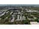 Aerial view of building with parking, mature trees and landscaping at 100 Glennes Ln # 207, Dunedin, FL 34698