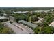 Aerial view of property showcasing surrounding lush greenery, parking, and multiple building units at 100 Glennes Ln # 207, Dunedin, FL 34698