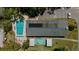 Aerial view of community pool and recreation area with shuffleboard court and parking at 100 Glennes Ln # 207, Dunedin, FL 34698