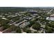 Aerial view of buildings with parking, lush trees and landscaping at 100 Glennes Ln # 207, Dunedin, FL 34698
