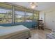 Relaxing bedroom with rocking chair and plentiful natural light from large windows with green outdoors view at 100 Glennes Ln # 207, Dunedin, FL 34698