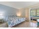 Comfortable bedroom featuring seaside themed bedding and a view of the screened-in patio at 100 Glennes Ln # 207, Dunedin, FL 34698