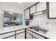 Kitchen view looking towards living room features stainless steel sink and dark wood trim at 100 Glennes Ln # 207, Dunedin, FL 34698