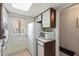 Bright kitchen featuring two-toned cabinets, white appliances, and a door to the outside at 100 Glennes Ln # 207, Dunedin, FL 34698