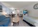 Open living area with wood-look floors, a sofa, and a passthrough window to the kitchen at 100 Glennes Ln # 207, Dunedin, FL 34698