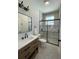 Modern bathroom featuring a wood vanity with a white countertop and a glass-enclosed shower at 107 E Park St, Tarpon Springs, FL 34689