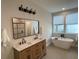 Stylish bathroom with double sink vanity, modern fixtures, soaking tub, and glass shower at 107 E Park St, Tarpon Springs, FL 34689