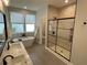 Bright bathroom featuring double windows, double sink vanity, soaking tub and glass shower at 107 E Park St, Tarpon Springs, FL 34689