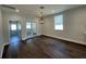 Formal dining room with hardwood floors, modern chandelier, and glass french doors to living room at 107 E Park St, Tarpon Springs, FL 34689