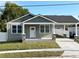 Charming exterior view of a renovated home, featuring a quaint front porch and covered driveway at 107 E Park St, Tarpon Springs, FL 34689