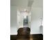 Hallway with hardwood floors, white walls, and view of a bathroom with tiled shower at 107 E Park St, Tarpon Springs, FL 34689
