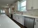 Modern kitchen with white cabinets, stainless steel appliances, tile backsplash, and stainless steel sink at 107 E Park St, Tarpon Springs, FL 34689
