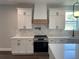 Well-equipped kitchen boasts stainless steel appliances, white cabinets, and hardwood floors at 107 E Park St, Tarpon Springs, FL 34689