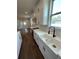 Modern kitchen with white cabinets, stainless steel appliances, tile backsplash, and stainless steel sink at 107 E Park St, Tarpon Springs, FL 34689