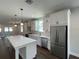 Modern kitchen features white cabinets, stainless steel appliances, quartz countertops, and a large island at 107 E Park St, Tarpon Springs, FL 34689