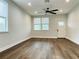 Bright living room with hardwood floors, ceiling fan, and two windows with abundant natural light at 107 E Park St, Tarpon Springs, FL 34689