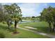 Scenic golf course view features lush green grass, sand trap, lake with fountain, and well-maintained landscaping at 11344 Heritage Point Dr, Hudson, FL 34667