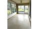 Enclosed sunroom with tile flooring and expansive windows showcasing the backyard at 11344 Heritage Point Dr, Hudson, FL 34667