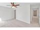 Neutral carpeted bedroom with a ceiling fan and direct access to a hallway at 11817 Mango Cross Ct, Seffner, FL 33584