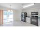 Bright eat-in kitchen with sleek black appliances, white cabinets and a sliding glass door to the brick patio at 11817 Mango Cross Ct, Seffner, FL 33584
