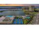 Stunning aerial view of the community amenities including tennis courts, pools, and miniature golf, with the bay in the background at 130 Riviera Dunes Way # 203, Palmetto, FL 34221