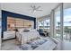 Bright bedroom with custom padded headboard, water views and access to the outdoor balcony with a view to the pool at 130 Riviera Dunes Way # 203, Palmetto, FL 34221