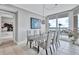 Bright dining room featuring a modern chandelier and a wall of windows showcasing a beautiful waterfront view at 130 Riviera Dunes Way # 203, Palmetto, FL 34221