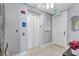 Hallway with elevator access, light walls, sconces, and tiled flooring at 130 Riviera Dunes Way # 203, Palmetto, FL 34221