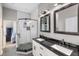 Well lit bathroom with white tiling, dual sinks and a glass shower next to a walk-in closet at 1423 W Wood St, Tampa, FL 33604