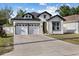 Two-story home showcasing a manicured lawn, neutral colors, and a spacious two-car garage at 1423 W Wood St, Tampa, FL 33604